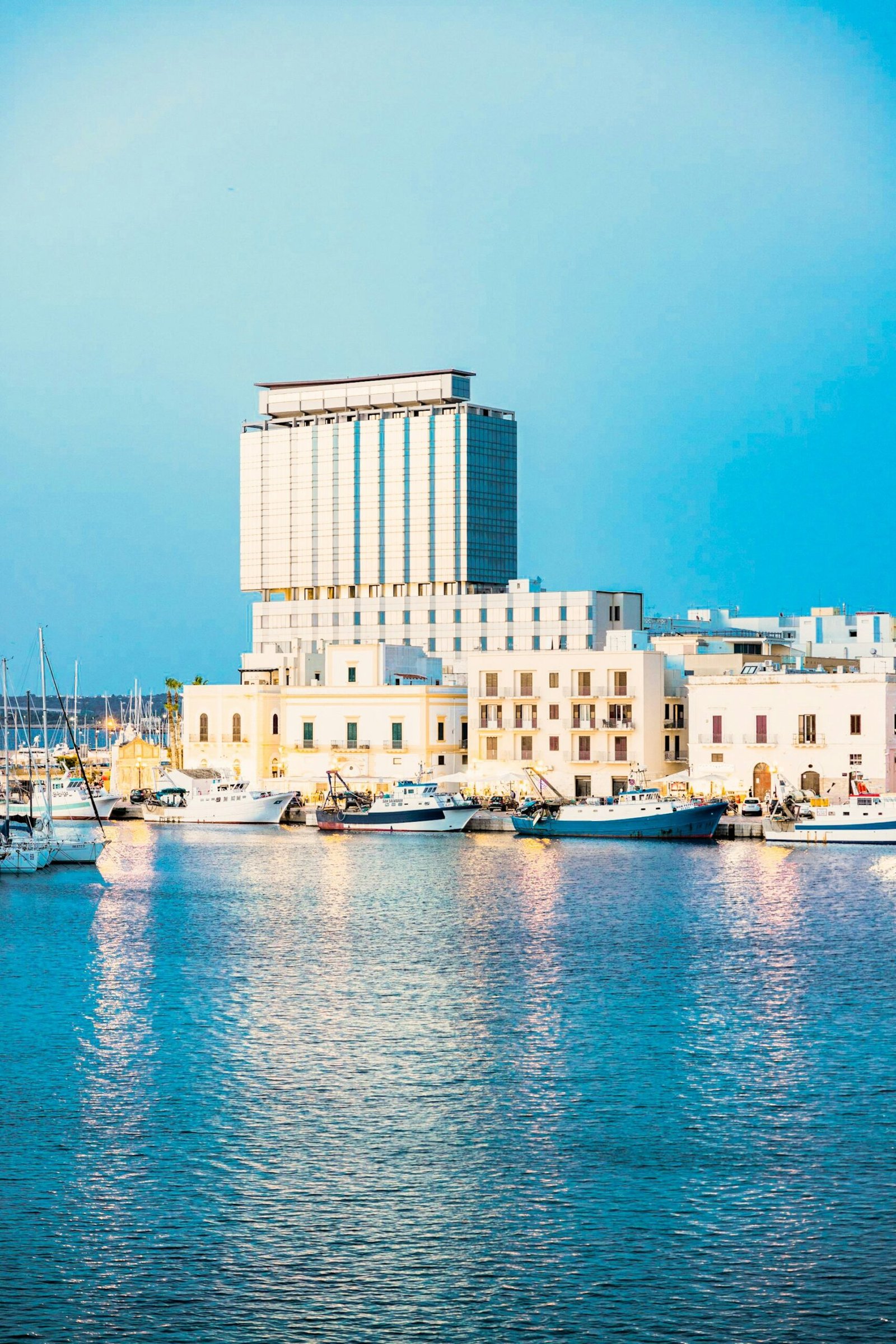 A harbor filled with lots of boats next to tall buildings