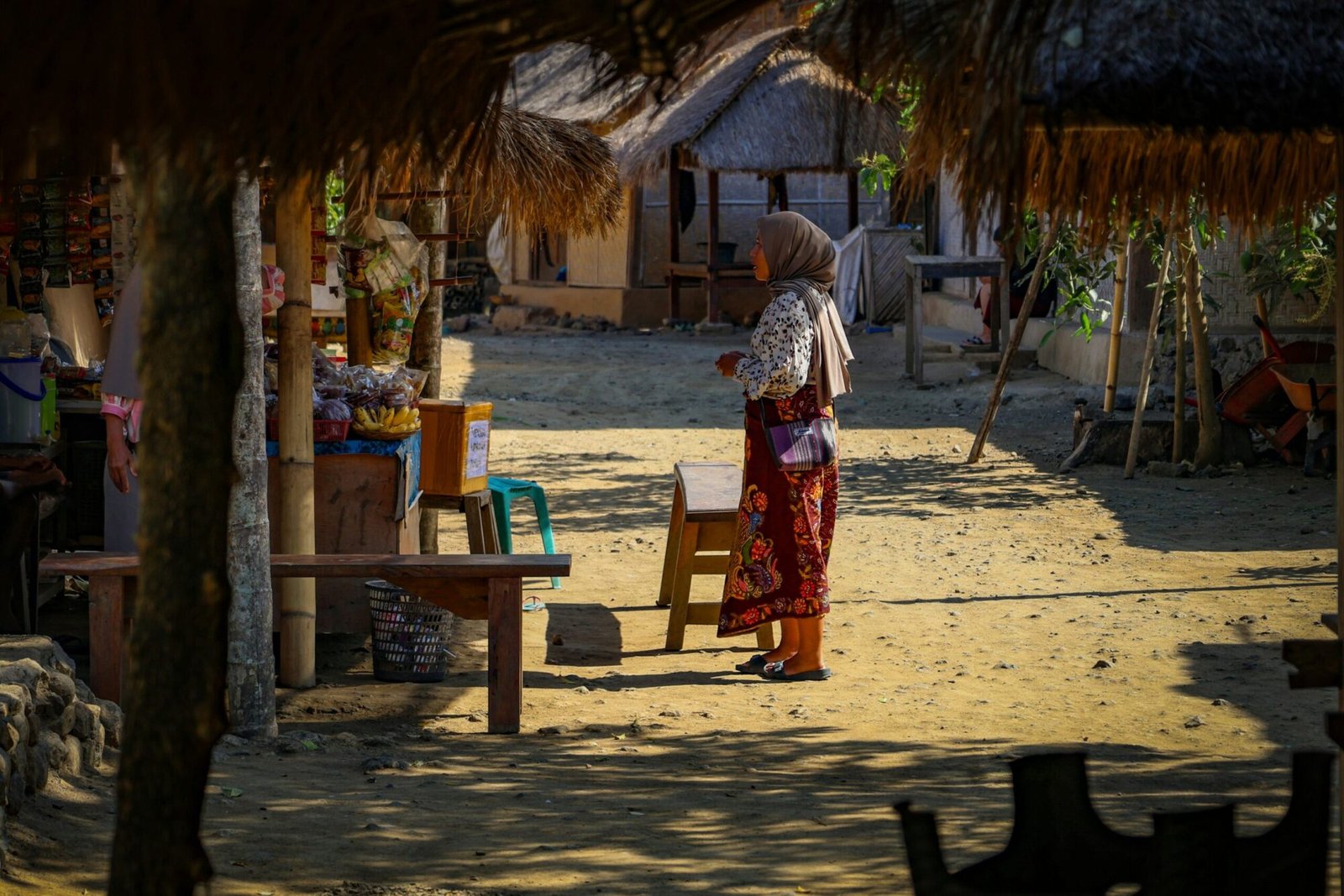 A woman standing in front of a hut