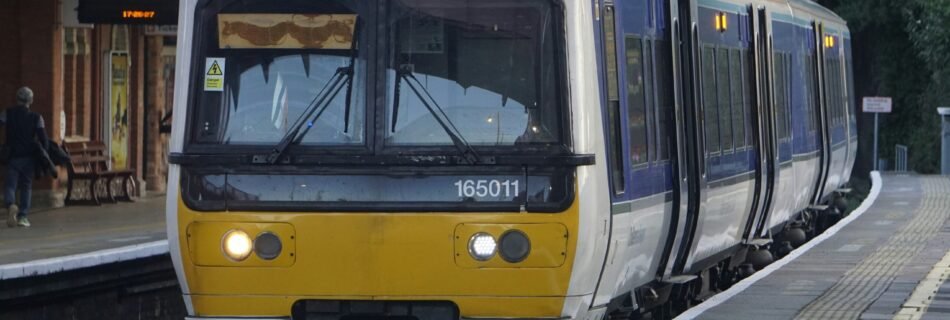 a yellow and white train pulling into a train station