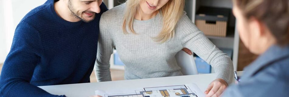 Young couple reviewing house plans with a real estate agent.