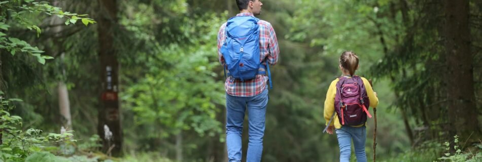 man in blue jacket and blue denim jeans walking on dirt road during daytime