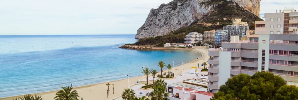 "Vibrant Mediterranean coastal town in Calpe with modern architecture and scenic views, showcasing the benefits of buying property in Calpe for expats."