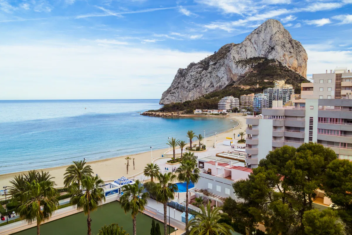 "Vibrant Mediterranean coastal town in Calpe with modern architecture and scenic views, showcasing the benefits of buying property in Calpe for expats."